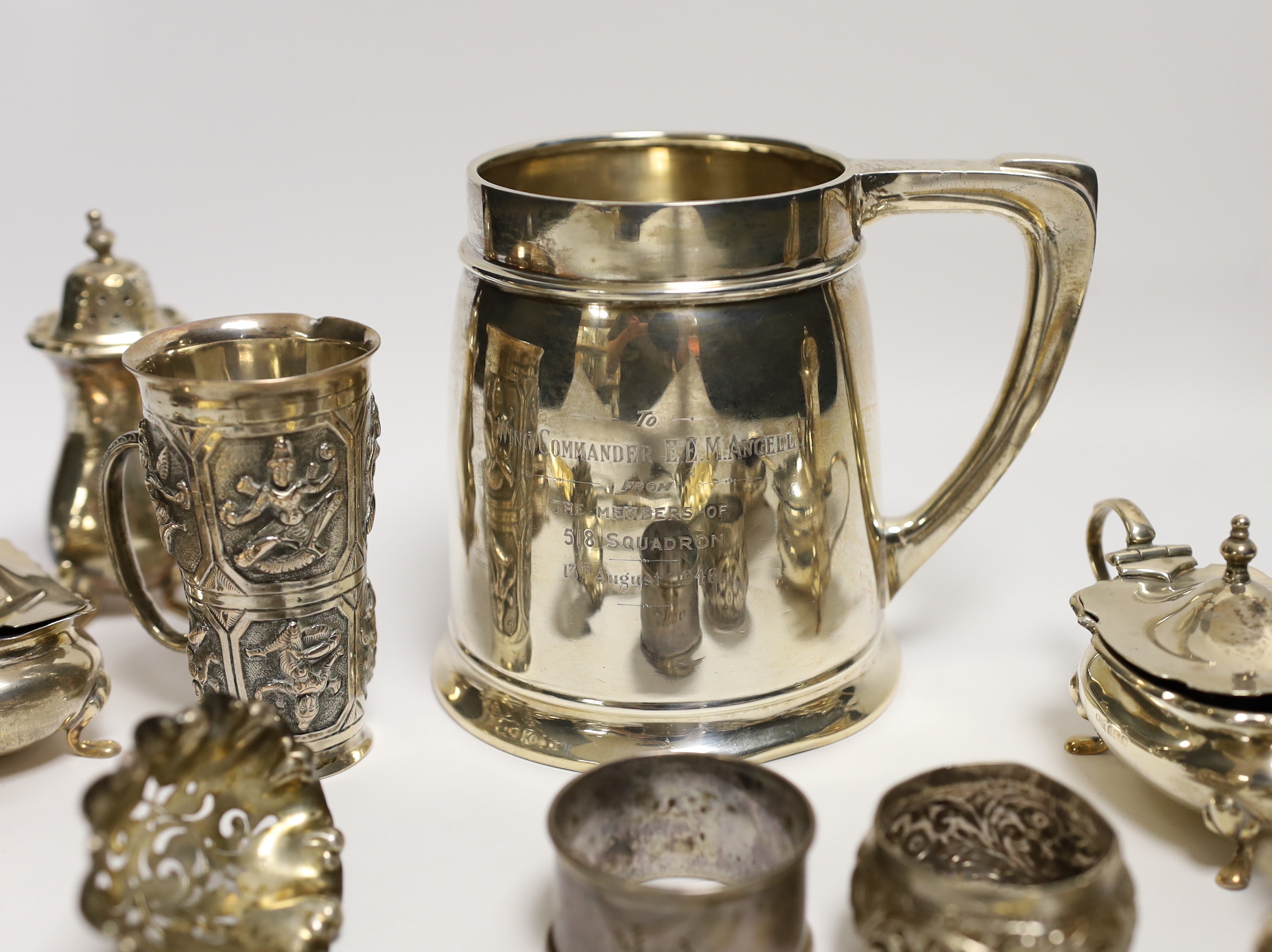 A George VI silver mug, Birmingham, 1937, 11.5cm with engraved inscription to Wing Commander E.E.M Angell, a pair of George III Old English pattern berry spoons, a George IV silver caddy spoons and other items including